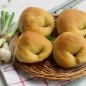Хлеб-пельмени сестёр Симили Муку просеять растереть с дрожжами, добавить соль, сахар, влить оливковое мало и воду, замесить тесто. Либо загрузить в ведерко ХП в последовательности предусмотренной инструкцией. Тесто должно увеличиться вдвое. Обмять тесто, выложить на стол, поворачивая, складывать края, прижимая тесто сверху. Даем снова подойти, а тем временем готовим начинку. Начинка: Фарш может быть любой, у меня свиная шея, пропустить через мясорубку. Почистить лук, мелко нарезать, разогреть сковородку, налить оливковое масло, пассеровать лук недолго 2 минуты, убрать половину лука. Добавить фарш, обжаривать 2-3 минуты. Снять с плиты и дать остыть. Фарш снова пропустить через мясорубку, так мне кажется, фарш становиться нежнее. Можете просто взять сырой фарш и не обжаривать лук, как это делали сестры Симали, но мне больше нравиться вот такой вариант. Добавляем в фарш, нарезанные оливки, я взяла оливок больше чем по рецептуре, уж очень я их люблю. Сыр натереть на терке, зелень порезать добавить в фарш. Посолить (не забудьте, что маслины солоноватые, осторожнее с солью, поперчить. Тесто разделить на две половины. Каждую часть раскатать, нарезать на квадраты 10*10 см В середину каждого квадрата выложить по 1 ст. л. начинки. Сложить треугольником и защипать хорошо края. Придать форму пельменя. Выложить на противень, смазать оливковым маслом, выпекать в разогретой духовке до 180 гр. Вот такой хлеб с начинкой получается.