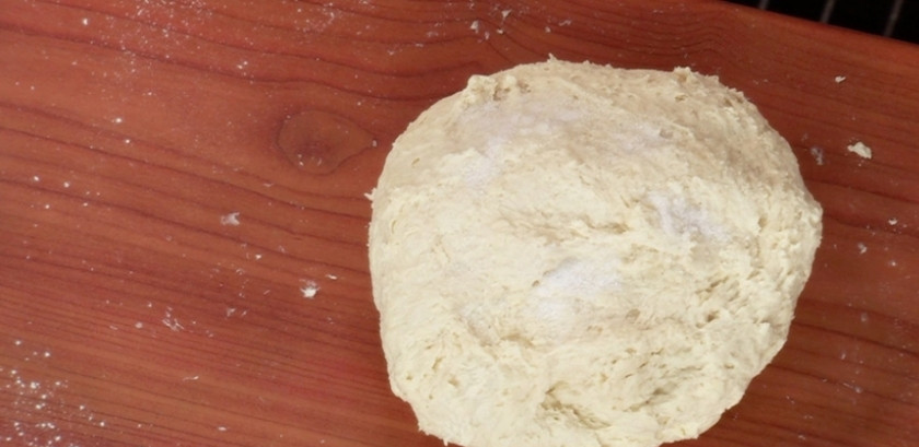 1. Этап. Осетинский пирог с сыром сулугуни: Выложите тесто на стол, продолжайте его вмешивать, присыпая солью и мукой. Сформируйте шарик, который затем следует обтянуть пищевой пленкой, предварительно поместив в миску. На расстойке он должен оставаться не менее двадцати минут.