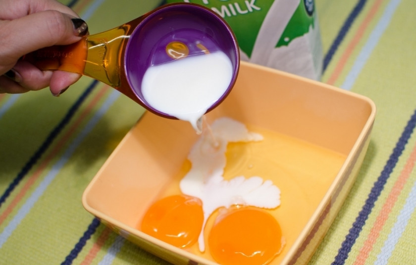 1. Этап. Простой омлет: Разбейте в глубокую чашку яйца и добавьте молока.