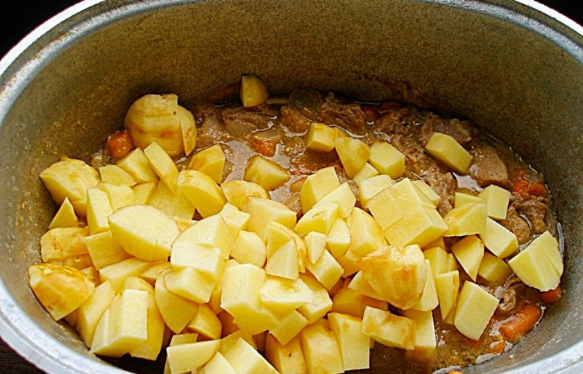 1. Этап. Венгерский бограч: Картофель чистим и нарезаем на кубики. Добавляем в казан к мясу, которое уже практически готово.