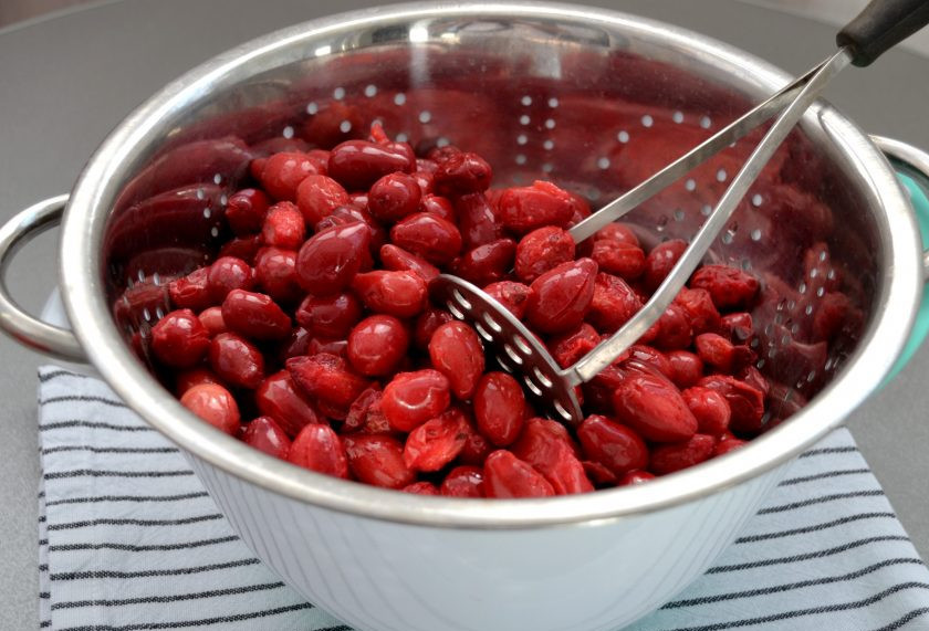 1. Этап. Сок кизиловый: Переложите ягоды в дуршлаг и с помощью толкушки протрите мякоть. При этом косточки остаются на решетке. Это самая сложная часть приготовления кизилового сока.