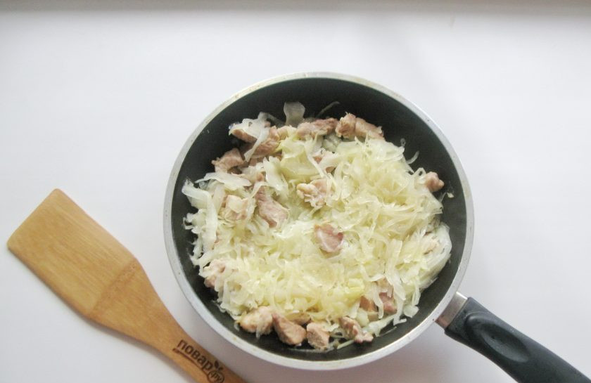 1. Этап. Корейская окрошка Кукси: Тушите свинину с капустой до готовности.