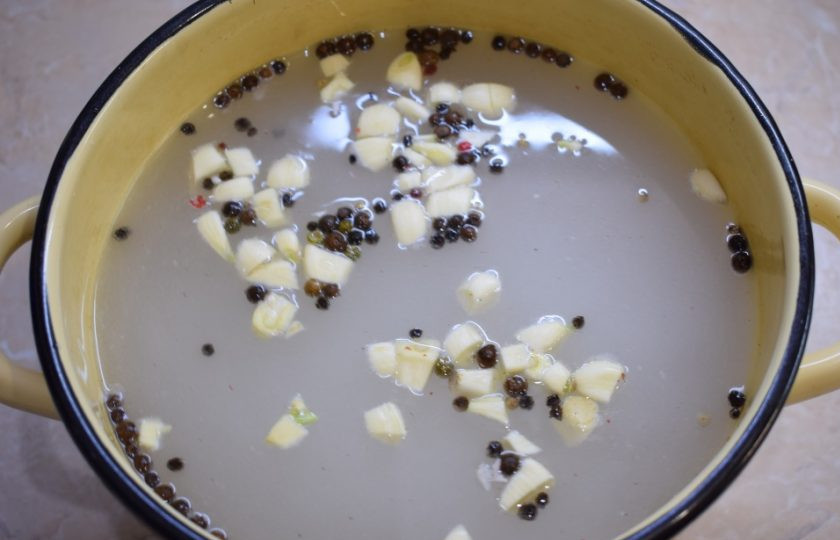 1. Этап. Маринад для копчения сала: В большую и широкую кастрюлю налейте воду и добавьте соль и сахар. Всыпьте перец. Зубчики чеснока нарежьте и добавьте к маринаду.