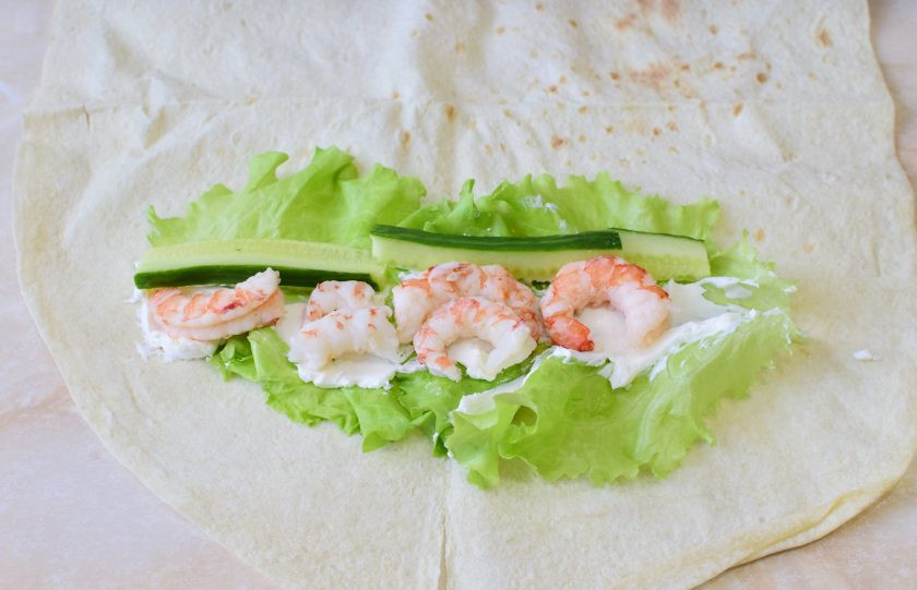 1. Этап. Сэндвич ролл с креветкой: Разложите огурец и креветки.