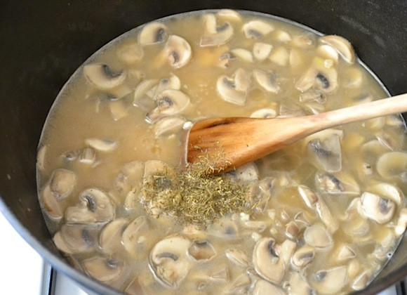1. Этап. Перловка с шампиньонами: 4. Залейте грибы в казане овощным бульоном, добавьте тимьян и прогрейте несколько минут.