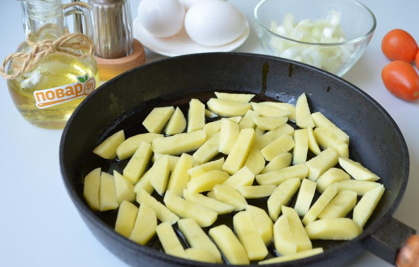1. Этап. Деревенская яичница: 2. Картофель очистите от кожуры, промойте под холодной водой, порежьте брусочками. Отправьте в горячее масло и жарьте на среднем огне до полуготовности. Луковицу очистите и нарежьте полукольцами.