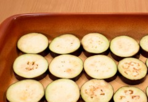 1. Этап. Баклажаны запеченные с томатами и сыром: 6. Баклажанные кружочки натрите чесноком.