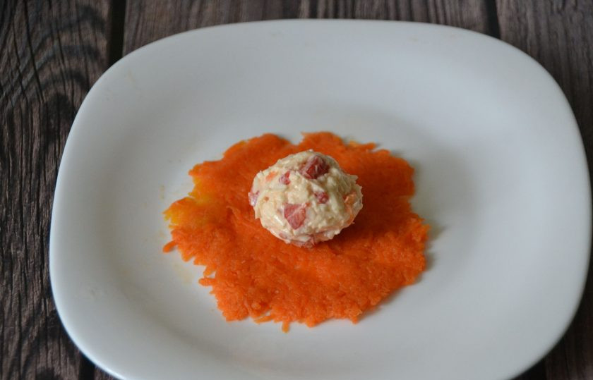 1. Этап. Сырная закуска Мандарины: Сделайте тонкий слой из моркови, скатайте сырную массу в шарик размером с грецкий орех, и аккуратно со всех сторон 