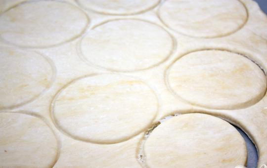 1. Этап. Ватрушки: 4. Приблизительно в полсантиметра раскатываем холодное тесто и по размерам приготовляемых ватрушек вырезаем кружки. Затем необходимо позагибать края у кружочков.