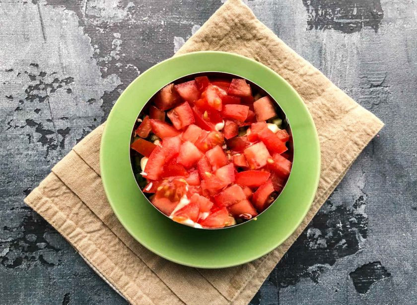 1. Этап. Салат Безумный с крабовыми палочками: Помидоры нарежьте кубами, выложите и посолите.