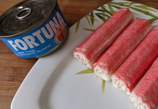 1. Этап. Крабовые палочки, фаршированные тунцом и сыром: Сворачиваем крабовую палочку в рулетик. Смотрите, чтобы розовая часть палочки была сверху, а не внутри. До употребления кладём фаршированные крабовые палочки в холодильник.