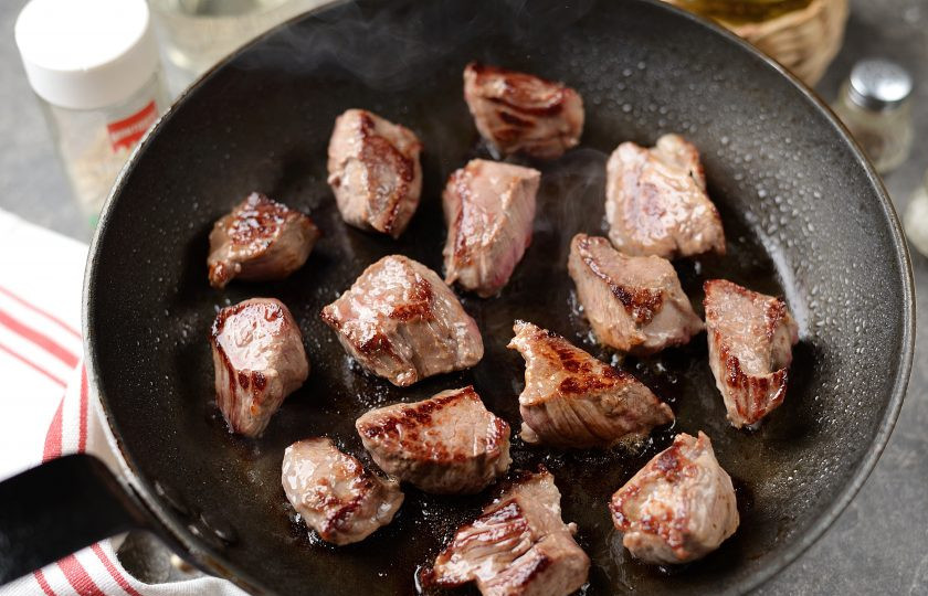 1. Этап. Говядина по-сицилийски: Влейте в разогретую сковороду оставшееся масло, выложите нарезанную крупными кусочками говядину, обжарьте со всех сторон до красивой румяной корочки.