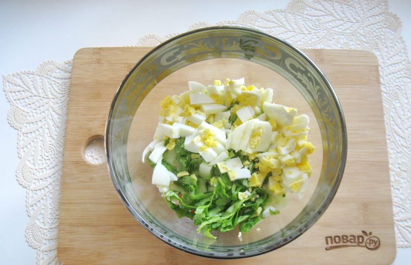 1. Этап. Зеленый салат с крабовыми палочками: Яйца сварите вкрутую, охладите, очистите и мелко нарежьте. Добавьте в салат.