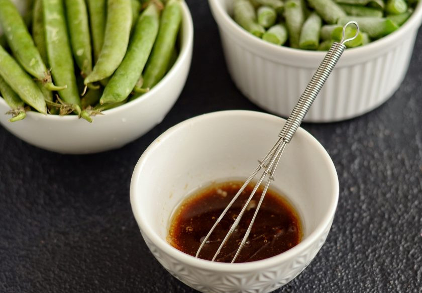 1. Этап. Салат из горошка и фасоли: Смешайте соевый соус, лимонный сок и оливковое масло. Добавьте тёртый чеснок.