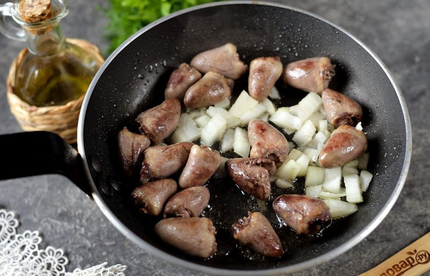 1. Этап. Куриные сердечки тушеные с тыквой в сметанном соусе: Уменьшите огонь, добавьте измельченный репчатый лук, накройте крышкой и жарьте минут 15-20. Подливайте время от времени воду.