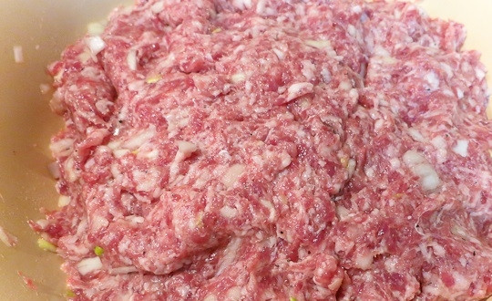 1. Этап. Беляши Советские: 6. Фарш выложите в миску, добавьте к нему лук, посолите и поперчите, влейте воду.