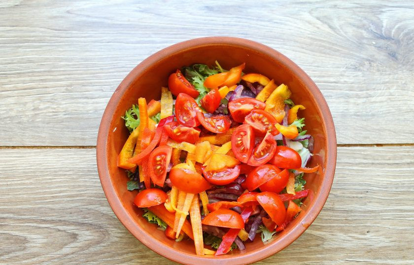 1. Этап. Салат с жареным тунцом: Черри порежьте на четыре части и добавьте в миску с салатом.