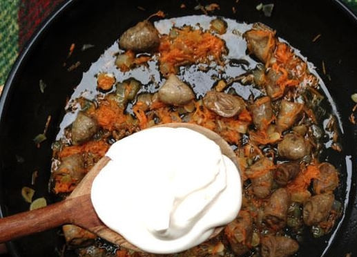 1. Этап. Жареные куриные сердечки со сметаной: Когда все подрумянится, добавьте морковку и жарьте еще 15 минут. Затем добавьте сметану и убавьте огонь.