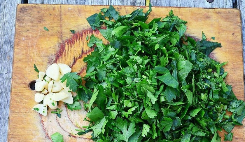 1. Этап. Борщ в казане на костре: Варите суп в течение 10 минут. Чеснок очистите и измельчите. Сельдерей и петрушку помойте и мелко нарежьте.