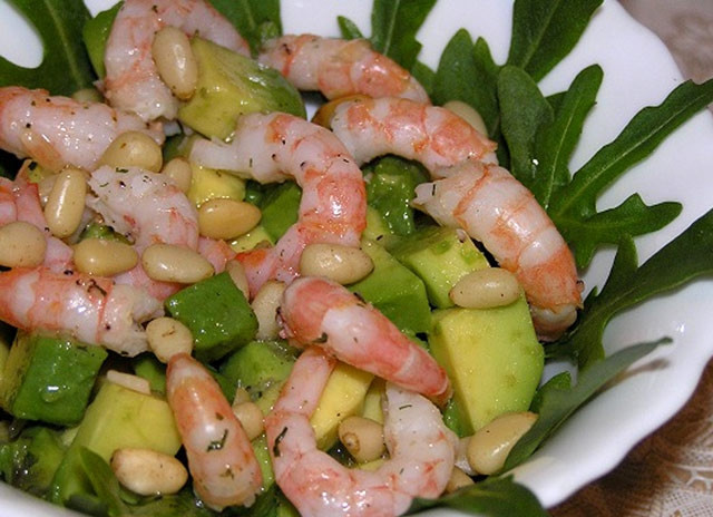 1. Этап. Cалат: авокадо с креветками: Соедините все ингредиенты в салат, выложив их в порционные небольшие пиалы на листы зелени. В качестве заправки используйте качественное оливковое масло. Приправьте салат солью и перцем, а также соком половинки лимона. Сверху насыпьте кедровые орешки.