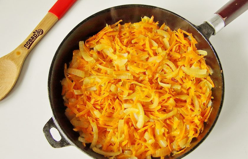 1. Этап. Баклажанная икра с помидорами через мясорубку на зиму: Лук нарежьте перьями, морковь натрите на терке. Обжарьте лук и морковь на сковороде до мягкости.