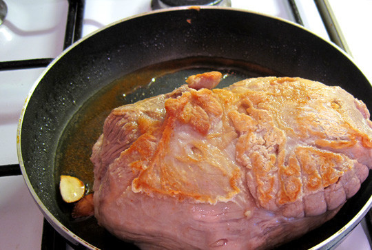 1. Этап. Буженина на сковороде: 1. Первым делом необходимо вымыть кусочек свинины и обсушить бумажным полотенцем. На сковороде разогреть оливковое масло и отправить туда 1 очищенный зубчик чеснока. Обжарить на сильном огне с двух сторон до появления корочки, чтобы запечатать все мясные соки.