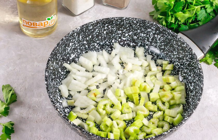 1. Этап. Суп из сельдерея с беконом: Очистите луковицу от шелухи, промойте в воде. Нарежьте мелкими кубиками. Промойте стеблевой сельдерей и нарежьте его мелкими кусочками. Отпассеруйте все в растительном масле на сковороде примерно 2-3 минуты.