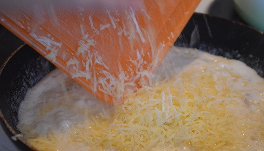 1. Этап. Сырно-грибной соус: Доводим сливки до кипения и добавляем тертый сыр.