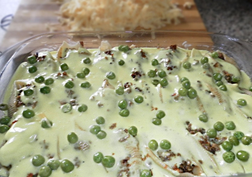 1. Этап. Ракушки под соусом Бешамель: 3. Для соуса: в сотейник кладу масло, добавляю муку, куркуму и мускатный орех, перемешиваю, тонкой струйкой вливаю горячее молоко и непрерывно помешиваю, чтобы не было комочков. Получившимся соусом заливаю ракушки в форме, сверху выкладываю зеленый горошек.