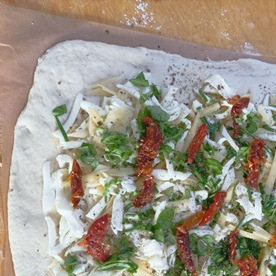 1. Этап. Итальянский хлеб стромболи: Готовое тесто обмять и раскатать в прямоугольник 30 х 23 см. Накрыть промасленной пищевой пленкой и оставить на 5 минут. Затем посыпьте его натертым сыром, не доходя до краев 1 см. Распределите остальные ингредиенты начинки.