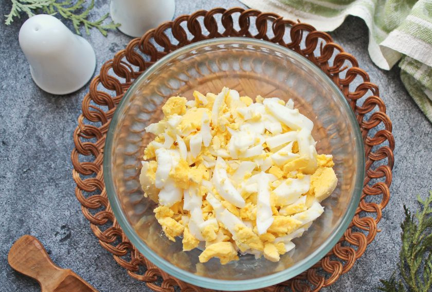 1. Этап. Салат из кальмаров с чесноком: Вареные яйца очистите и порежьте полосками, добавьте в салатник.