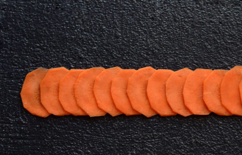 1. Этап. Розы из моркови: Выложите 15-20 морковных кружочков в ровный ряд. Каждый следующий кружочек должен закрывать половину предыдущего.