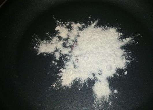 1. Этап. Жульен в горшочках с картошкой: Возьмите чистую сухую сковородку с антипригарным покрытием и поставьте ее на плиту. Разогрейте сковородку и уменьшите огонь. На сухую поверхность высыпьте ложку муки.