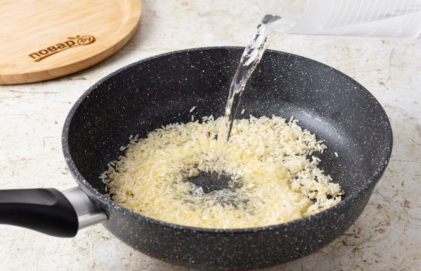 1. Этап. Рис с миндалем и изюмом: Влейте горячую воду, посолите и перемешайте. Варите на небольшом огне 10 минут.