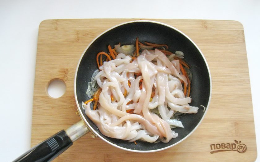 1. Этап. Кальмары с луком на сковороде: Кальмар нарежьте соломкой и добавьте в сковороду с луком и морковью. Посолите и поперчите по вкусу.