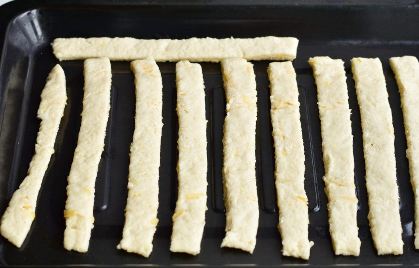 1. Этап. Творожно-сырные палочки: Выложите полоски теста на противень.