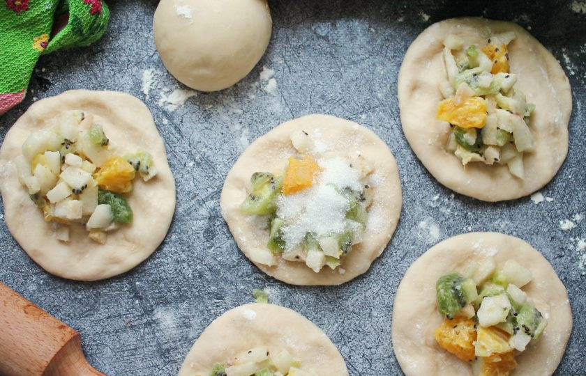 1. Этап. Пирожки с фруктами в духовке: Тесто раскатайте в лепёшки и выложите начинку, сверху посыпьте сахаром.