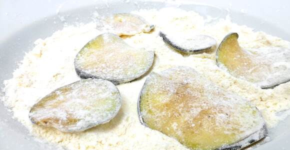 1. Этап. Баклажаны, жаренные в панировке: 3. Подготовить глубокую мисочку, в которую всыпать муку. При желании в рецепт приготовления баклажанов, жареных в панировке можно добавить щепотку ароматных трав - орегано, базилик и т.д. Обвалять каждый кружочек как следует в муке.