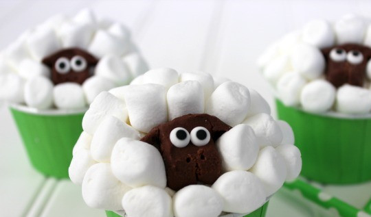 1. Этап. Кексы Овечка: Осталось собрать десерт. Наполняем бумажные или силиконовые формы масляным кремом. Из маленьких зефирок, делаем овечью шерсть. Устанавливаем шоколадную голову на нужное место. Ставим 