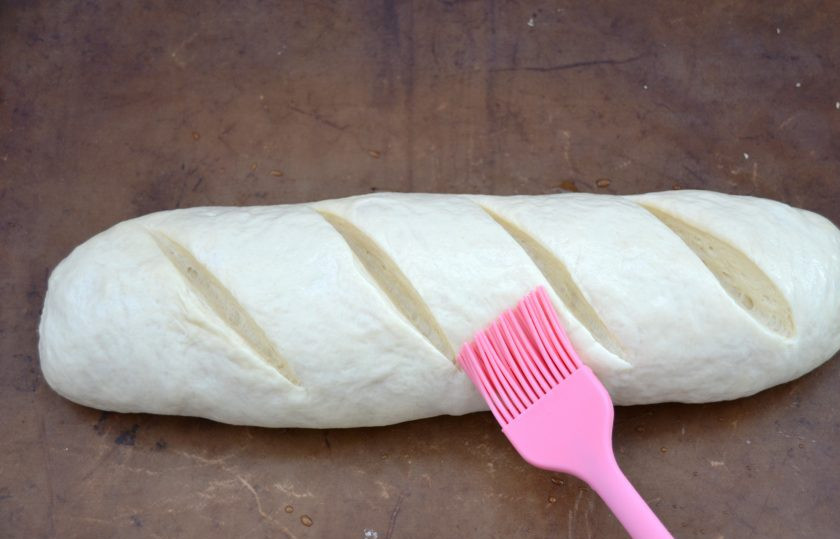 1. Этап. Батон на кефире: Острым ножом сделайте на батоне надрезы, смажьте водой при помощи кулинарной кисти. Выпекайте при температуре 200 градусов 40-45 минут.