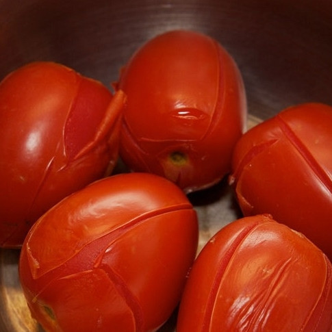 1. Этап. Лазанья с мясом: Начнем с приготовления соуса. На помидорах делаем крестообразные надрезы, кладем их в кипящую воду и держим там 15-20 секунд. Затем воду сливаем, а помидоры отставляем в сторону - пускай остывают.