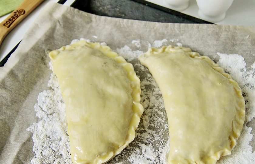 1. Этап. Корниш пасти: Противень застелите бумагой для выпечки, присыпьте ее мукой и выложите пироги. Смажьте поверхность взбитым желтком и отправьте в разогретую до 180 градусов духовку на 50-60 минут.