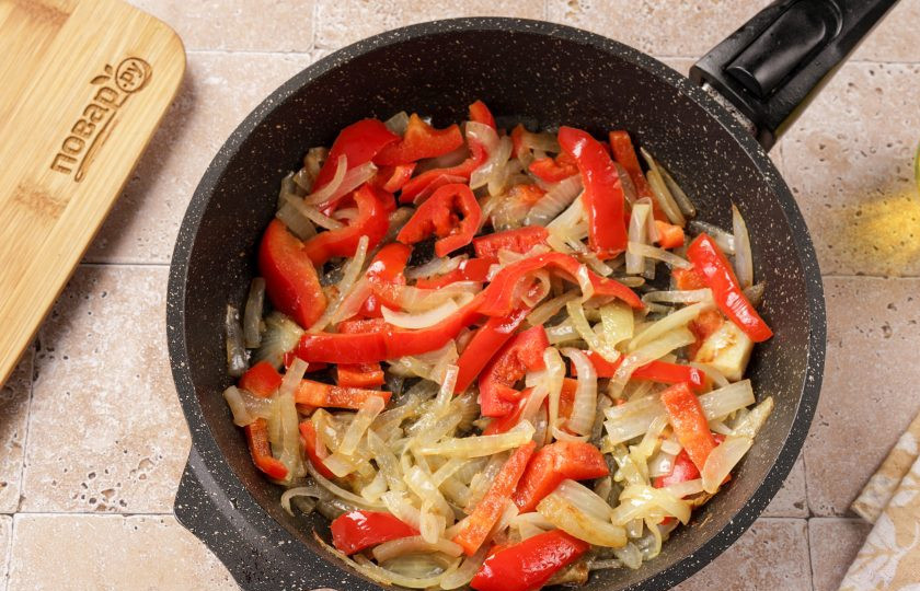 1. Этап. Минтай тушёный с перцем: На другой сковороде обжарьте нарезанный полукольцами лук и болгарский перец. Сильно овощи не зажаривайте, они должны стать мягкие.