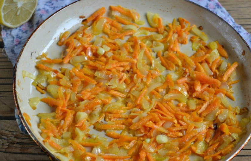 1. Этап. Запеченная скумбрия в фольге с морковью: 4. Обжарьте лук до прозрачности, затем добавьте морковь и готовьте до мягкости обоих ингредиентов.