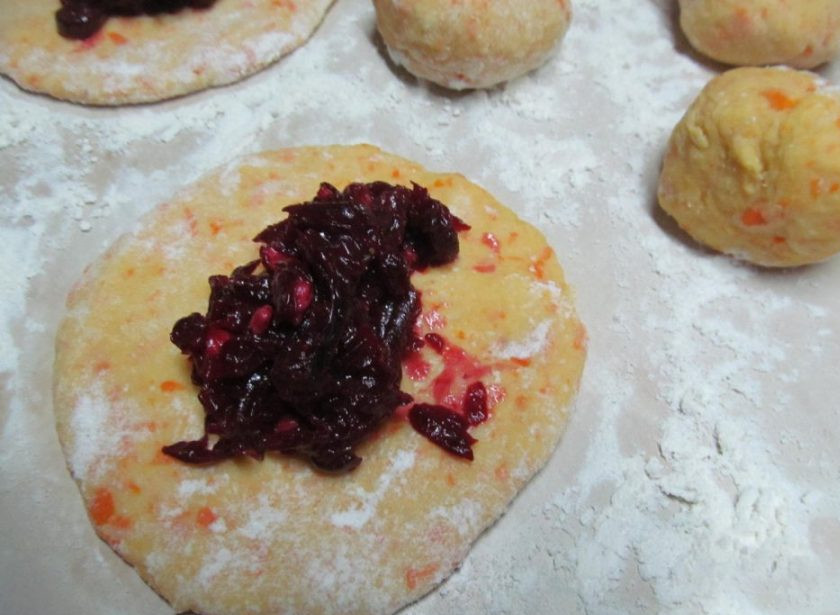 1. Этап. Пирожки со свеклой: Разделите получившееся тесто на 8-10 частей, каждую из которых распластайте в лепешку толщиной в 0,5 см. Выложите в середину лепешки свекольную начинку, защипните края, формируя пирожок.