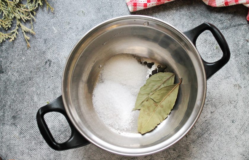 1. Этап. Горячий маринад для рыбы: В кастрюлю насыпьте соль, перец и добавьте лавровые листья. Влейте в кастрюлю горячую воду, уксус, добавьте перец горошком и поставьте на средний огонь. Доведите все до кипения.
