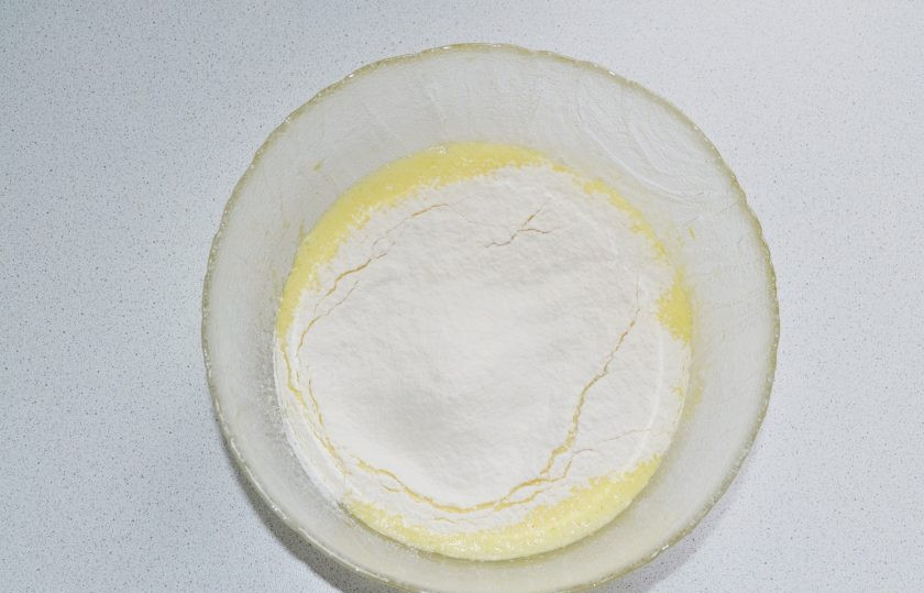 1. Этап. Шарлотка со сливами в мультиварке: Всыпьте просеянную муку и продолжайте взбивать.