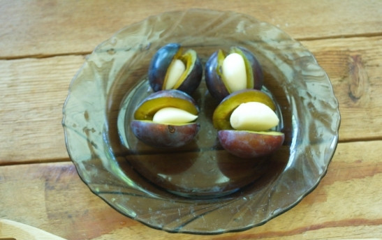 1. Этап. Маринованные сливы с чесноком: Вместо косточки в каждую сливу вложите по зубчику чесночка. Слишком большой зубчик можно разрезать.