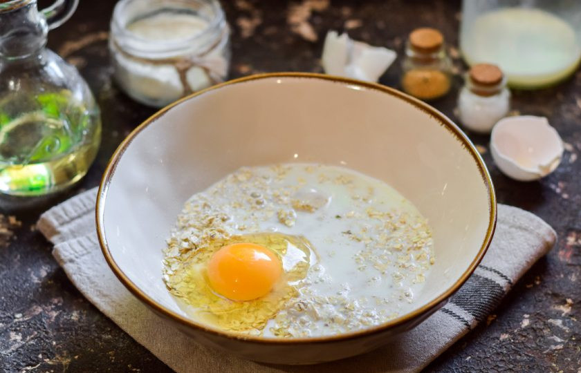 1. Этап. Оладьи из овсяных хлопьев: Влейте теплое молоко в миску с овсянкой.