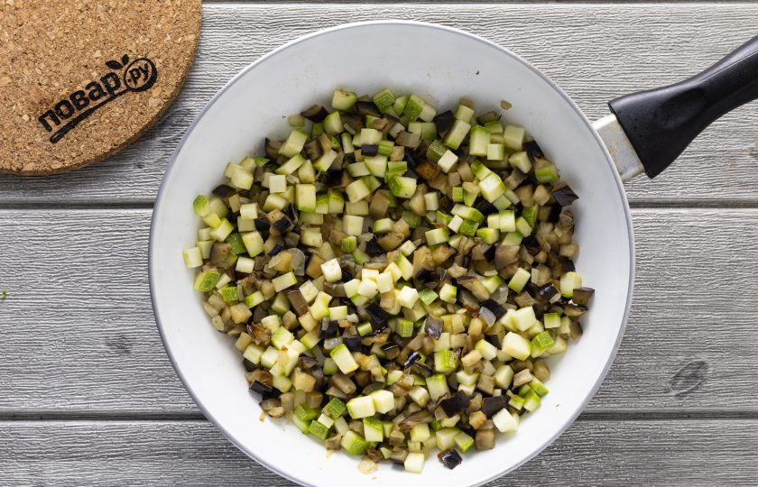 1. Этап. Овощная лазанья из кабачков и баклажанов: Разогрейте сковороду с растительным маслом на среднем огне. Обжарьте в начале чеснок и репчатый лук до прозрачности. Затем добавьте баклажан и жарьте его несколько минут до мягкости. Следом добавьте кабачок, тушите до испарения лишней жидкости. Приправьте солью и черным молотым перцем по вкусу.